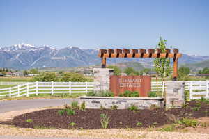 Community / neighborhood sign featuring a rural view, fence, and a mountain view