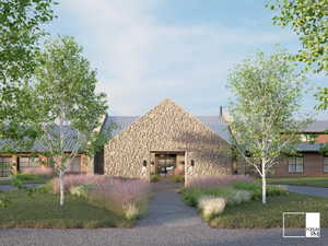 Stone facade entry with a pitched metal roof, flanked by mature trees and landscaped plantings
