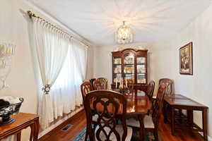 Dining area with living room and hall entrance, natural light
