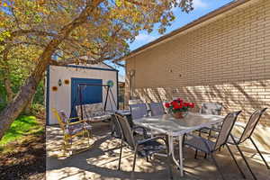 View of patio / terrace with outdoor dining space and a storage shed