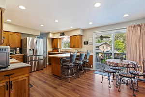 Kitchen featuring stainless steel fridge and bar with stool space, sliding door to deck