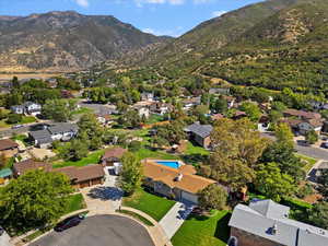 Aerial view of property and surrounding area with mountains and nearby suburban area
