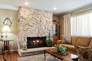 Formal Living room featuring a stone wood burning fireplace and laminate floors