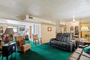 Living area featuring a textured ceiling and carpet