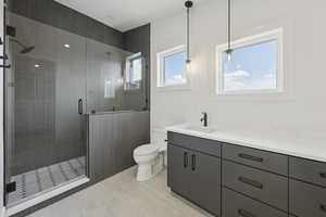 Full bathroom with a shower stall, vanity, and light tile patterned flooring