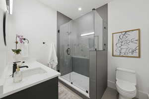 Full bathroom featuring vanity, a stall shower, and recessed lighting