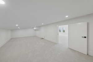 Below grade area featuring light colored carpet and recessed lighting