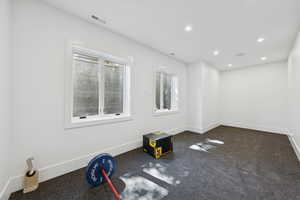 Unfurnished room with dark carpet and recessed lighting