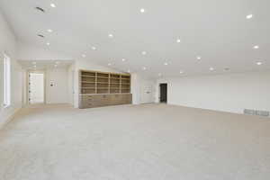 Spare room featuring vaulted ceiling, recessed lighting, and light colored carpet