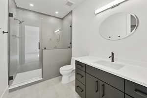Bathroom with a shower stall, vanity, light tile patterned floors, and recessed lighting