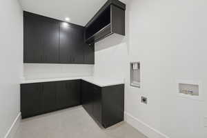 Laundry room with hookup for a washing machine, cabinet space, and hookup for an electric dryer