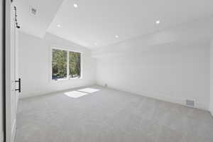 Unfurnished room with vaulted ceiling, light carpet, and recessed lighting