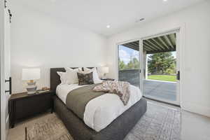 Bedroom with access to exterior, a barn door, and recessed lighting