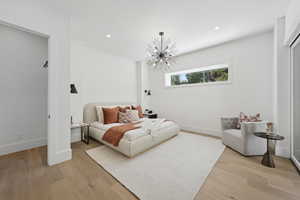Bedroom with recessed lighting, light wood-type flooring, and a chandelier