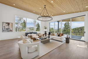 Living area with recessed lighting, wood-type flooring, wood ceiling, and a chandelier