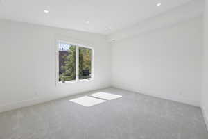 Carpeted spare room featuring recessed lighting