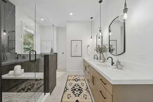 Bathroom with double vanity, recessed lighting, a shower stall, and light tile patterned floors