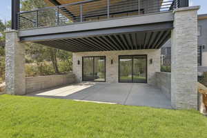 Back of house featuring a patio, a balcony, and a yard