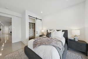 Bedroom featuring a barn door, recessed lighting, and a walk in closet
