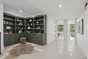 Office space with recessed lighting, a barn door, built in study area, and dark speckled floor