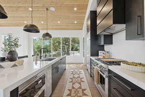 Kitchen featuring hanging light fixtures, light stone countertops, wall chimney range hood, wooden ceiling, and recessed lighting