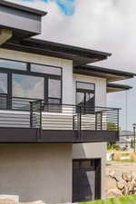 View of side of home with a balcony and stucco siding