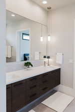 Bathroom with double vanity, recessed lighting, and light tile patterned flooring