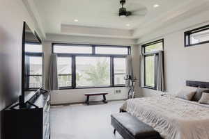 Bedroom with a tray ceiling, recessed lighting, a ceiling fan, and light wood-style floors