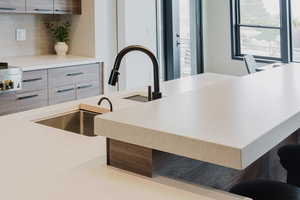Kitchen view of modern cabinets, tasteful backsplash, and a breakfast bar