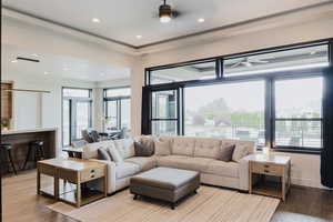 Living room with wood finished floors, recessed lighting, and a ceiling fan