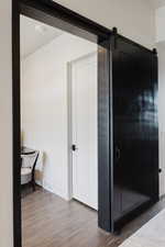 Hallway featuring a barn door and wood finished floors