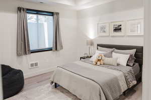 Bedroom with wood finished floors and baseboards