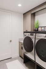 Laundry room with separate washer and dryer, recessed lighting, and cabinet space