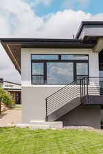 Doorway to property featuring stucco siding and a lawn