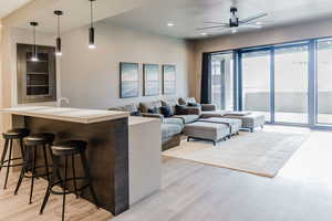 Living area with recessed lighting, light wood finished floors, and a ceiling fan