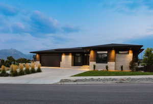 Prairie-style home with concrete driveway, an attached garage, and a mountain view