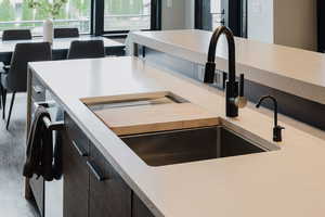 Kitchen featuring light countertops, dark brown cabinets, and plenty of natural light