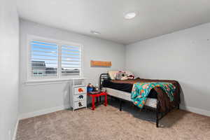 Bedroom with light colored carpet and baseboards