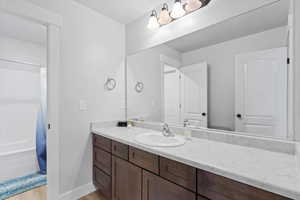 Bathroom with vanity, light wood finished floors, and shower / tub combo with curtain