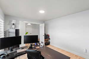 Home office with light wood-style floors and baseboards