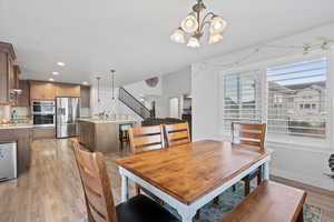 Dining room featuring stairs, light wood finished floors, recessed lighting, and a chandelier