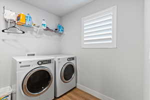 Washroom with light wood finished floors and independent washer and dryer