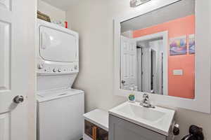 Bathroom featuring vanity and stacked washer / drying machine