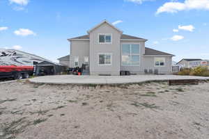 Back of house featuring a patio area, stucco siding, and a shingled roof