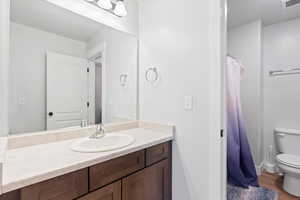 Full bath featuring vanity, dark wood-style floors, and a shower with shower curtain