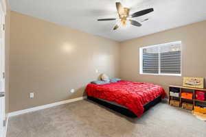 Carpeted bedroom featuring ceiling fan and a textured ceiling
