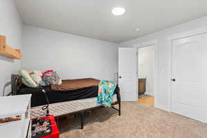 Bedroom with light colored carpet and baseboards