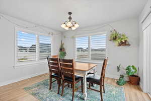 Dining area with light wood-type flooring and a chandelier