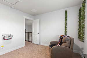Living area with baseboards and carpet
