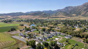 Aerial view of property and surrounding area with nearby suburban area, rural landscape, and a water and mountain view